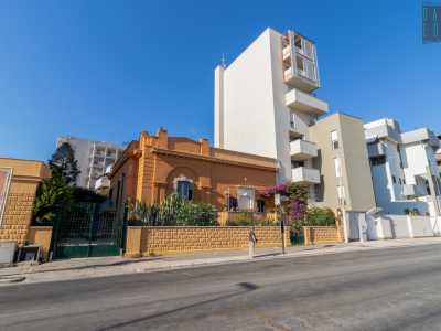 ...demolito per edificare un alto immobile bianco